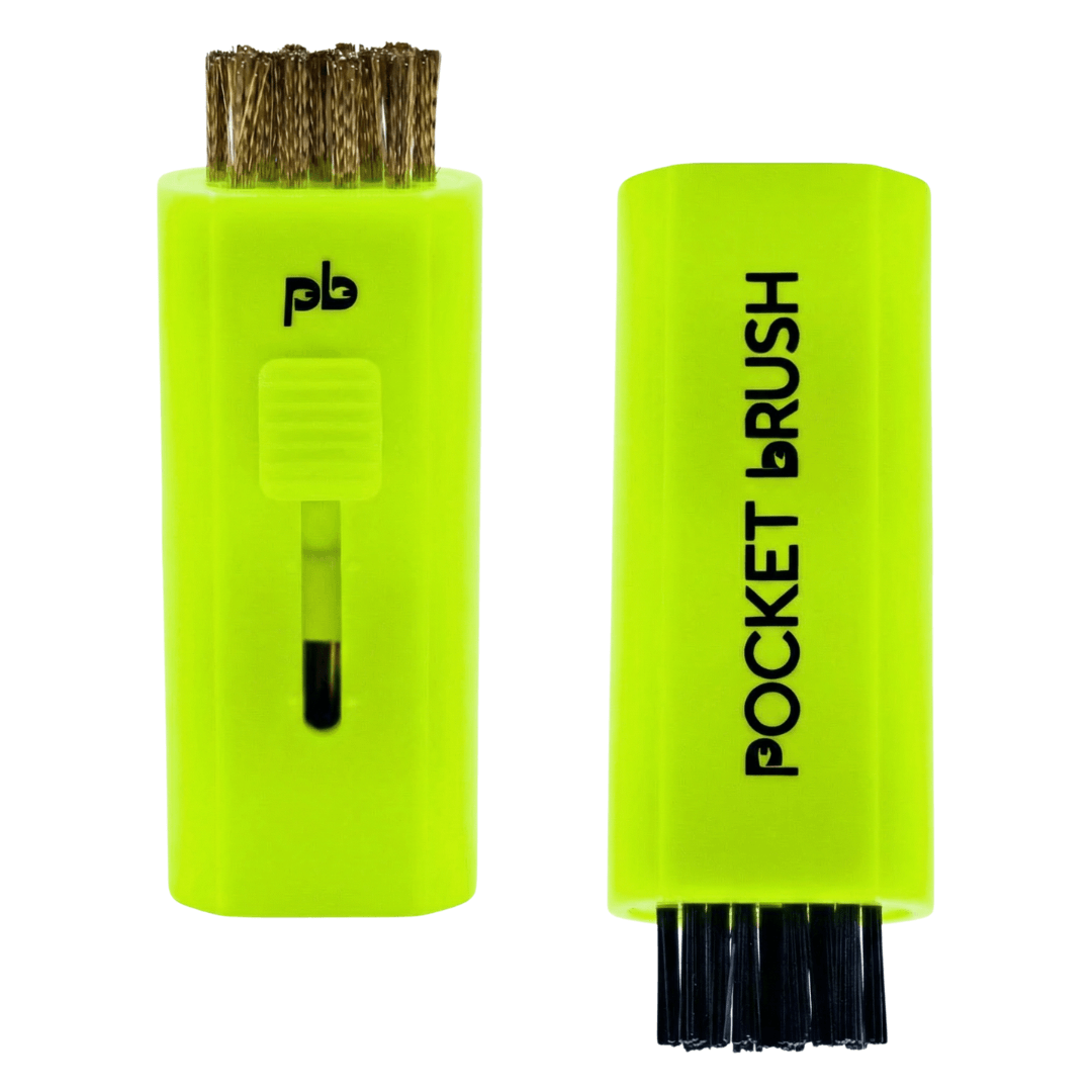 A neon yellow Pocket Brush golf club brush and groove cleaner with both the brass and nylon bristles exposed lies on a white background.