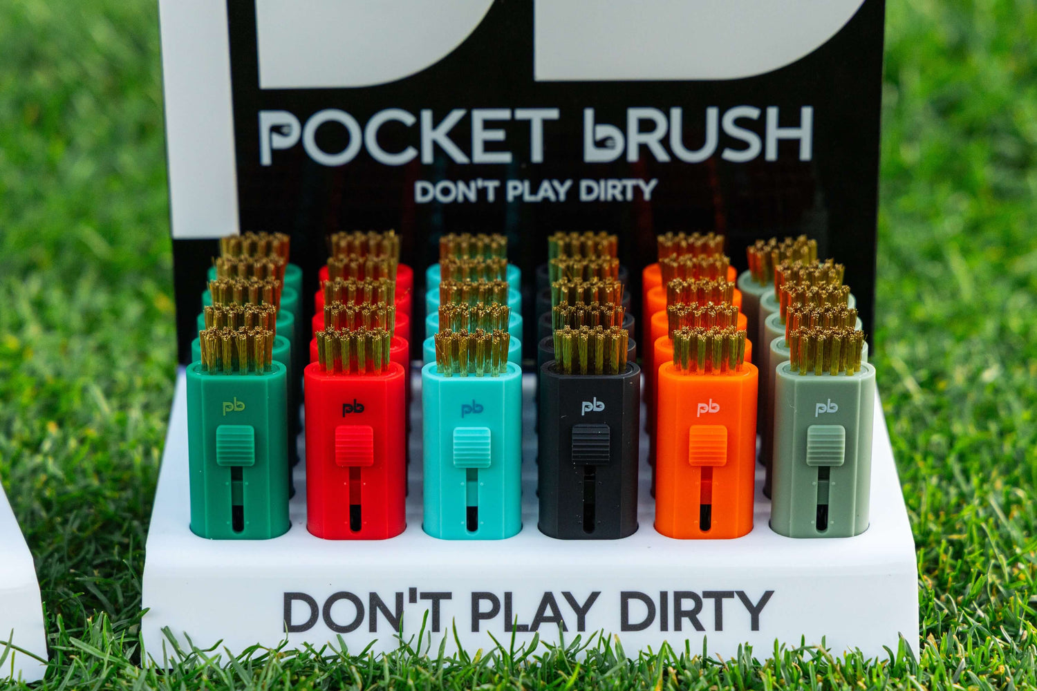 Set of colorful pocket brushes on a display stand with 'Don't Play Dirty' branding.