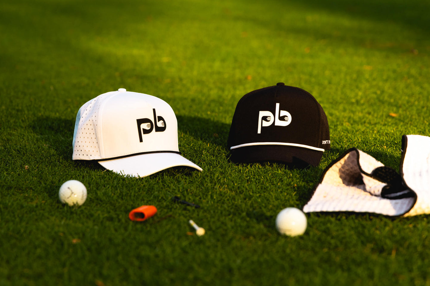 Two caps with 'Pocket Brush' logo on a grassy surface